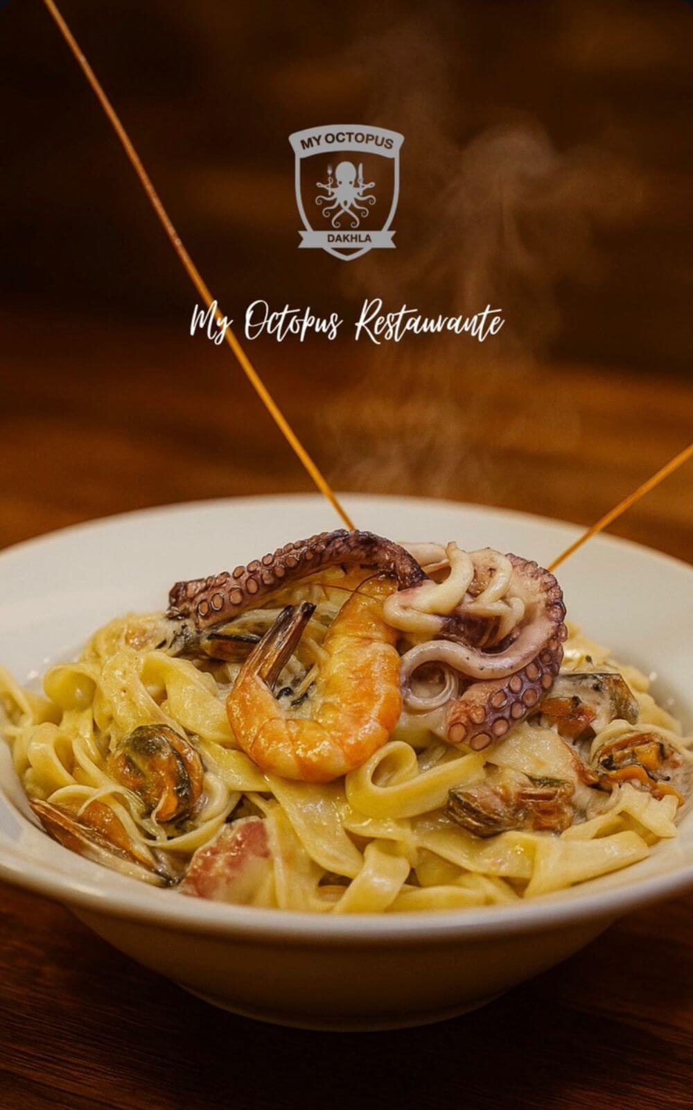 Bowl of creamy tagliatelle pasta topped with shrimp, octopus tentacles, and mussels, served hot with visible steam rising, branded with My Octopus Dakhla logo.